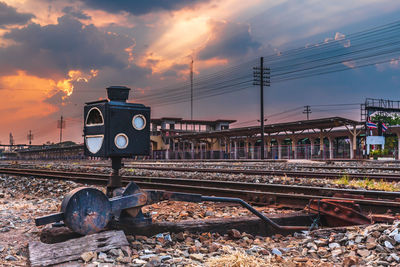 Train by railroad tracks against sky during sunset