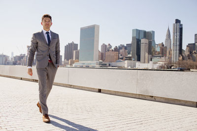 Portrait of a young businessman on a rooftop overlooking the city