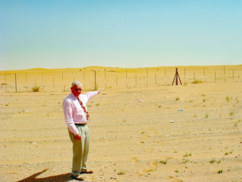 Full length of senior man standing at desert during sunny day