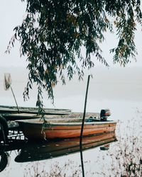 Boat moored on lake against sky