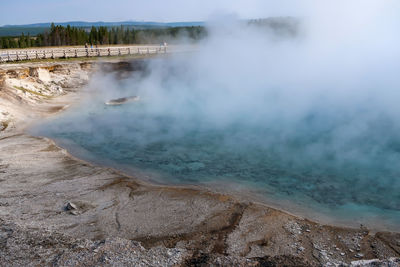 Landscape of blue geyser pool and steam at yellowstone national park