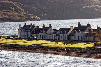 Houses by sea against buildings