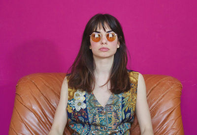 Portrait of beautiful young woman against pink wall