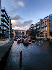 Buildings in city against cloudy sky