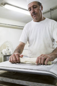 Baker kneading bread in a bakery