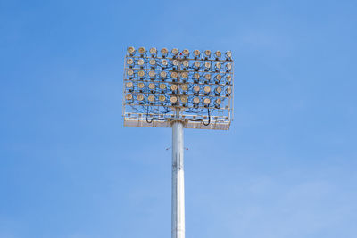 Low angle view of floodlight against blue sky