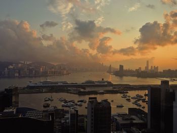 High angle view of sea and buildings against sky during sunset