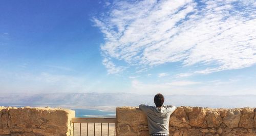 Rear view of man at observation point against sky