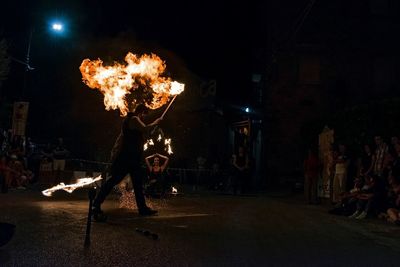 Man with fire crackers in city at night