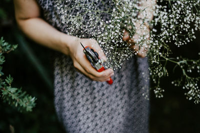 Midsection of woman holding plant
