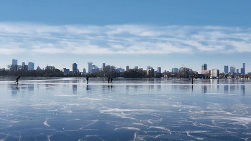 Scenic view of lake by buildings against sky