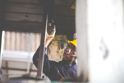 Portrait of man repairing metal structure at factory