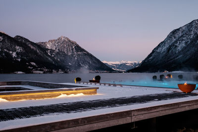 Scenic view of lake by mountains against clear sky