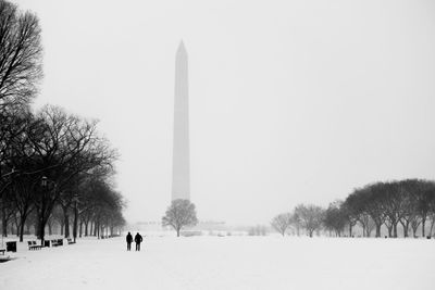 Snowcapped field against washington monument in foggy weather