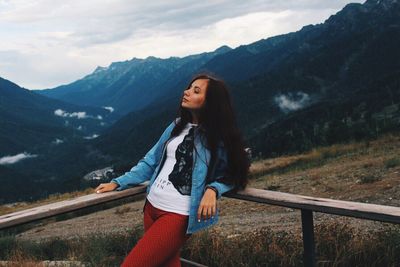 Full length of young woman on mountain against sky
