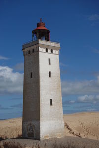 Lighthouse by sea against sky