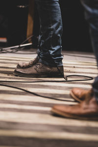 Low section of people standing on wood