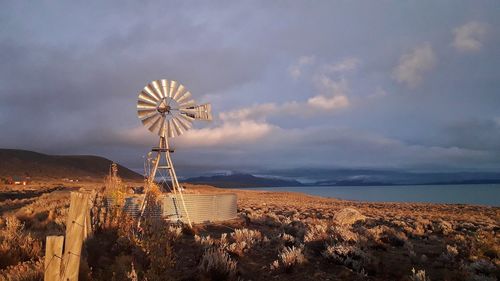 Traditional windmill on land against sky