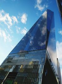 Low angle view of modern building against cloudy sky