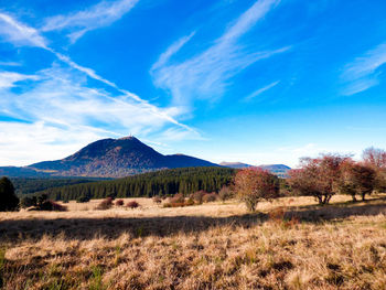 Scenic view of land and mountains against blue sky