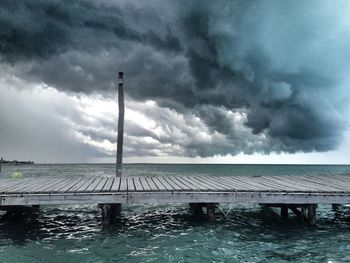 Scenic view of swimming pool by sea against storm clouds