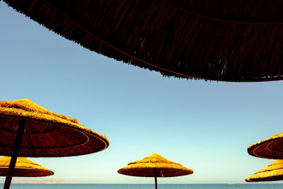 Low angle view of umbrellas against clear sky