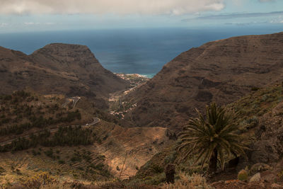 Scenic view of sea and mountains against sky