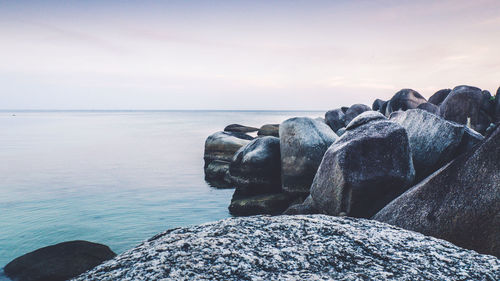 Rocks by sea against sky