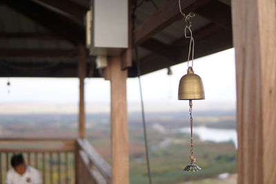 Close-up of electric lamp hanging on roof of building