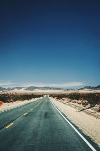 Empty road amidst land