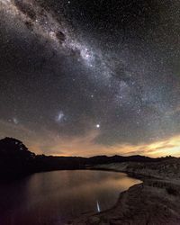 Scenic view of landscape against star field at night