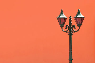 Low angle view of street light against orange sky