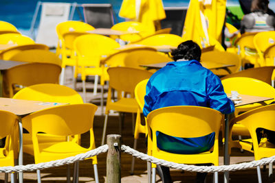 Rear view of man sitting on chair