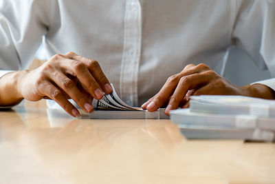 Midsection of man working on table