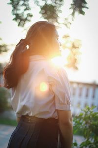 Rear view of woman standing against sky
