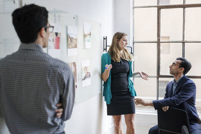 Business people discussing during meeting at brightly lit office