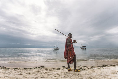 Man standing on beach against sky