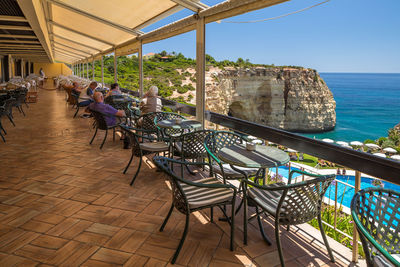 People in restaurant by sea against sky