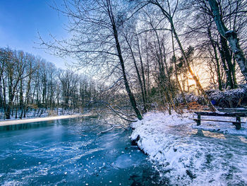 Scenic view of frozen river against sky during winter