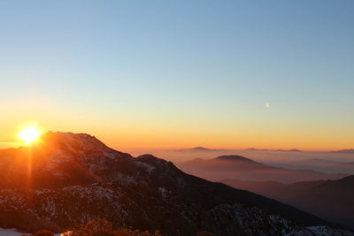 Scenic view of mountains against clear sky during sunset