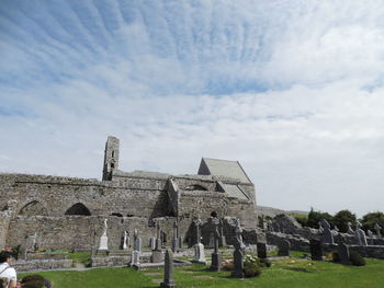 Cemeteries outside corcomroe abbey against cloudy sky