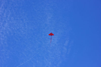 Low angle view of kite flying against blue sky