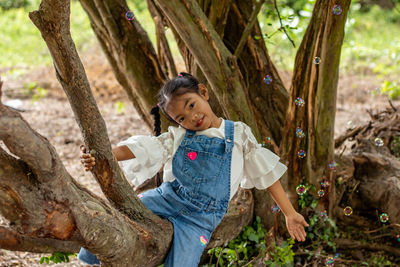 Girl smiling on tree trunk