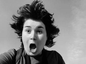 Close-up of woman screaming against sky