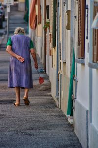 Rear view of senior woman walking on street