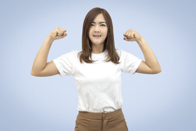Portrait of smiling young woman against white background