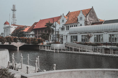 View of buildings by river in town