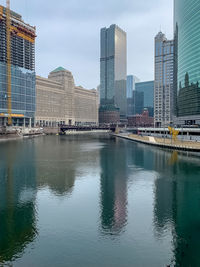 Reflection of buildings in city against sky