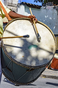 Midsection of man playing drum with sticks