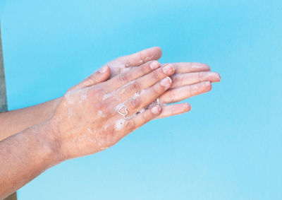 Close-up of hand against blue background